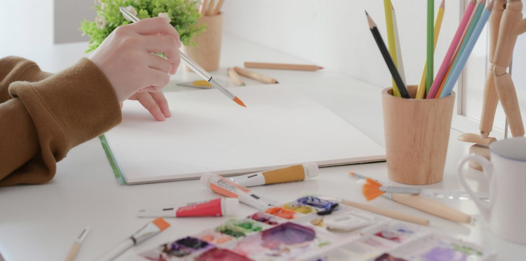 Child Using Watercolor Paint Pen Brush Painting On Top Of Removed Sticker