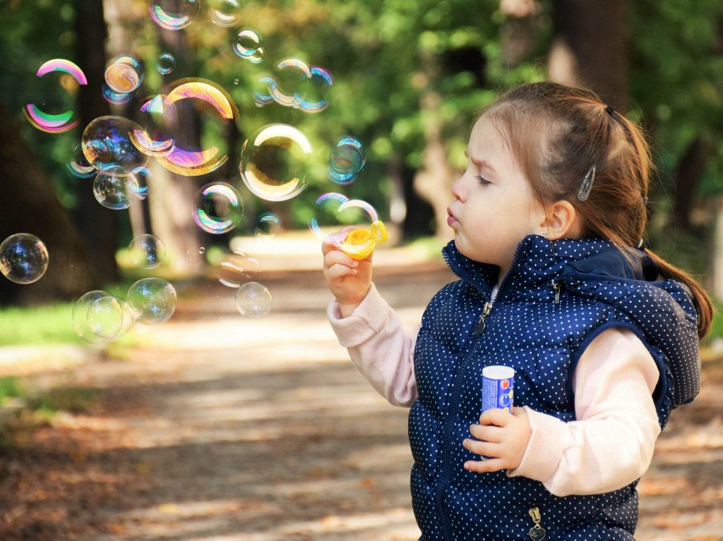 Girl Blowing Bubbles Outdoors