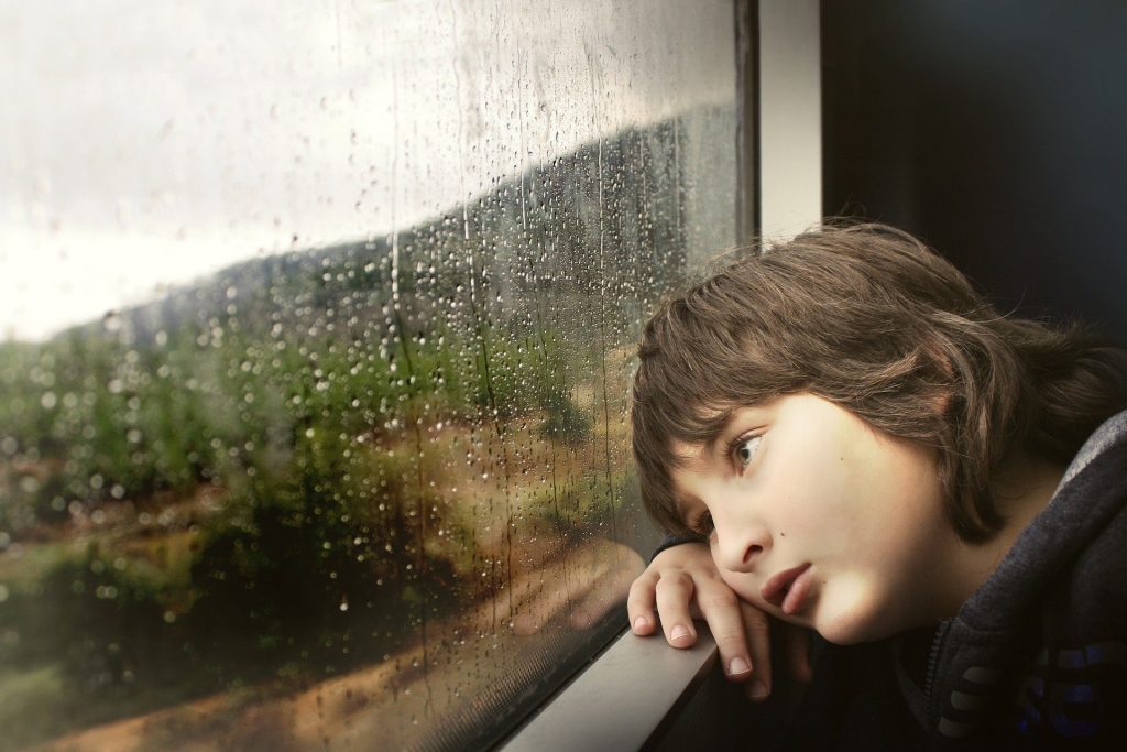 Kid Thinking By Rainy Window