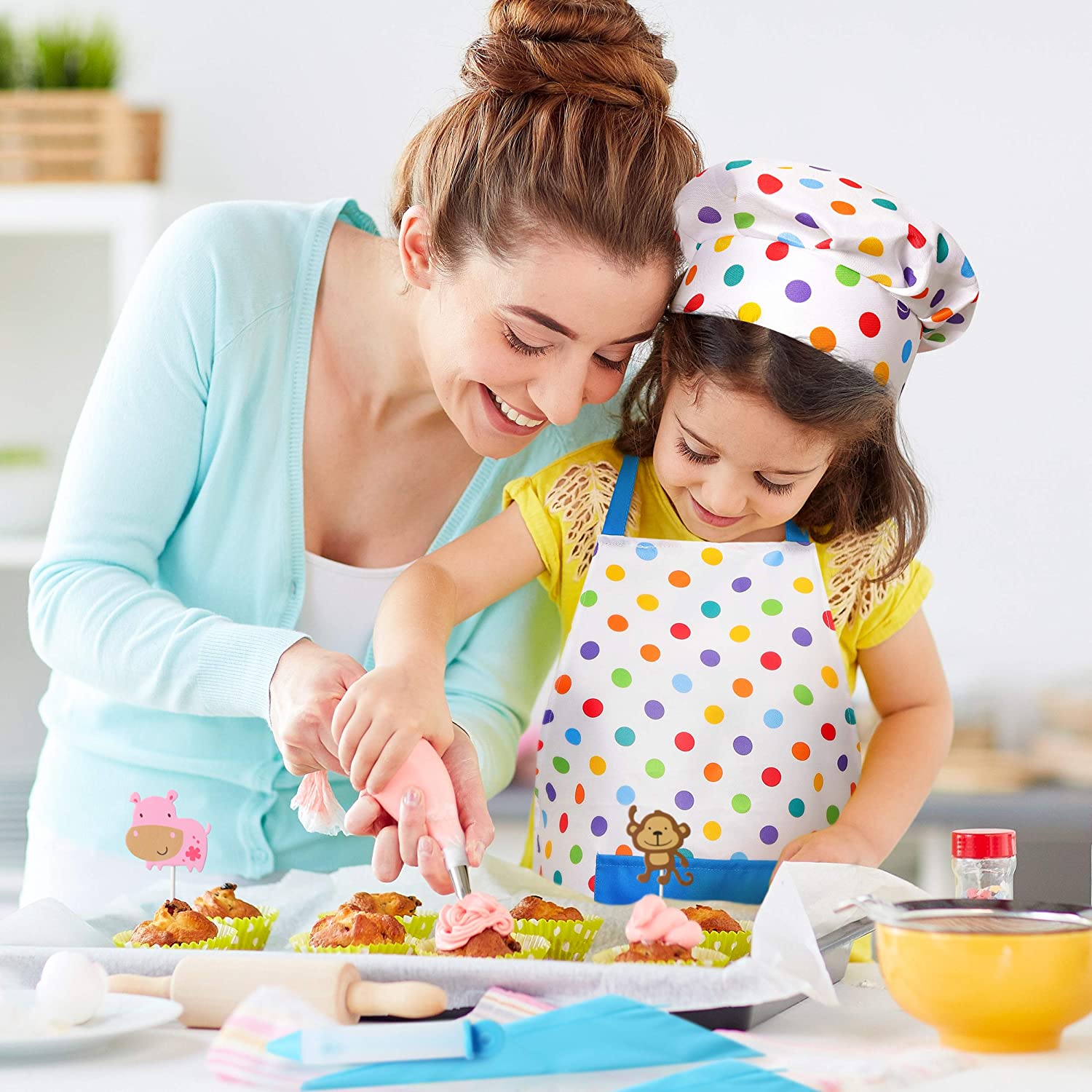 Mother And Daughter Wearing Polka Dot Apron And Chef Decorating Cupcakes