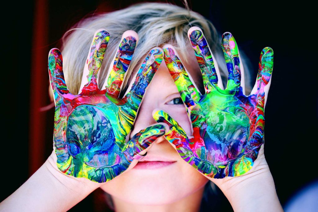 Young Boy With Acrylic Paint Covering Hands