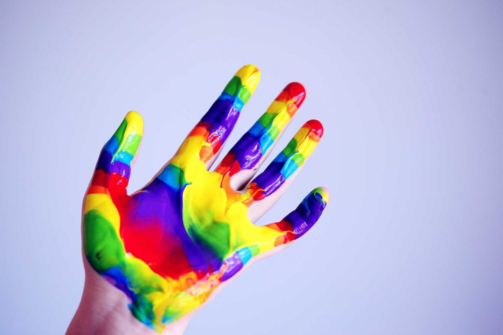 Young Hand Cover In Rainbow Paint