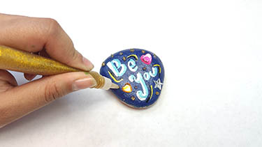 Kindness Rock Painting Tutorial Step 12: Add Gold Glitter Glue All Over