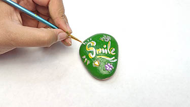 Kindness Rock Painting Tutorial Step 6: Adding Line And Dot Details With A Fine Brush
