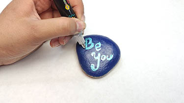 Kindness Rock Painting Tutorial Step 9: Add An Outline To Inspirational Text With Another Colored Acrylic Paint Marker